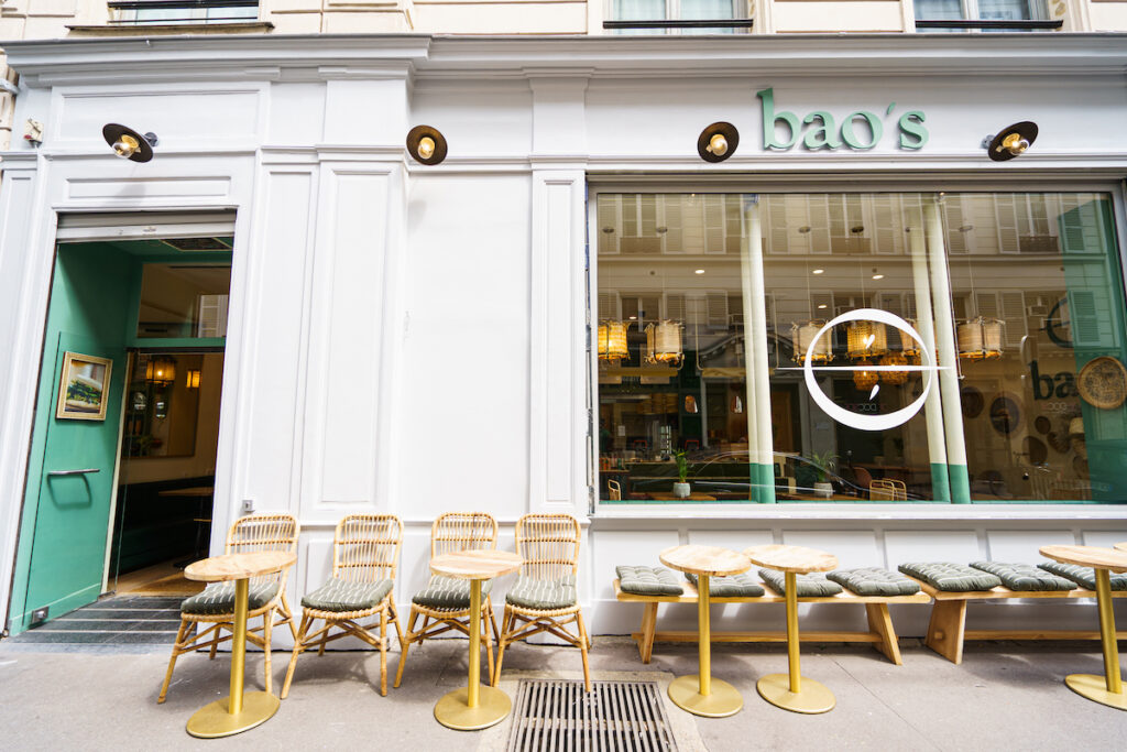 Street view of a modern restaurant storefront with outdoor seating and clear branding.
